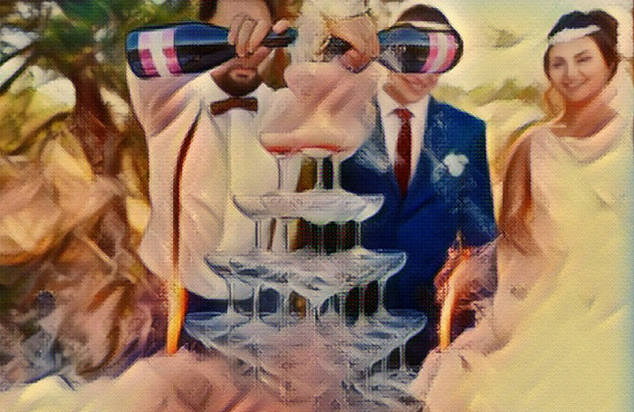 A bride and groom pouring a champagne tower at their wedding reception.