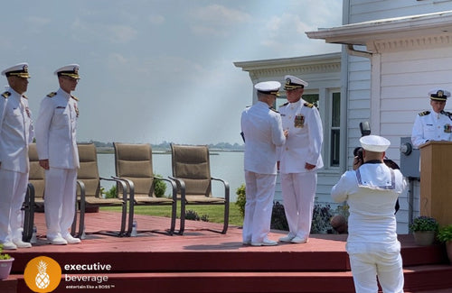 U.S. Navy officers in dress whites at an outdoor military ceremony served by Executive Beverage.