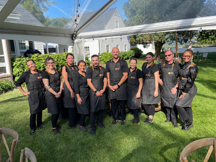 The Executive Beverage bartending crew in branded aprons at a wedding in Virginia Beach.