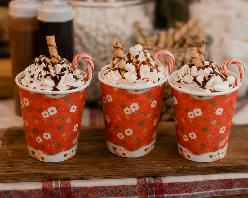 Hot chocolates topped with whipped cream and a chocolate stick
