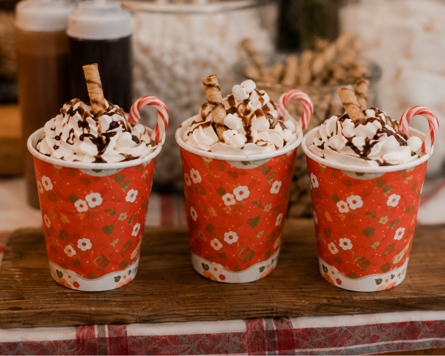 Hot chocolates topped with whipped cream and a chocolate stick