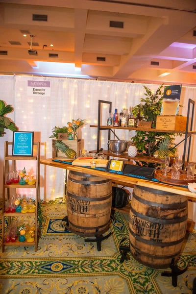 Authentic Tarnished Truth whiskey barrel bars set up with a bar top at a Hampton Roads event