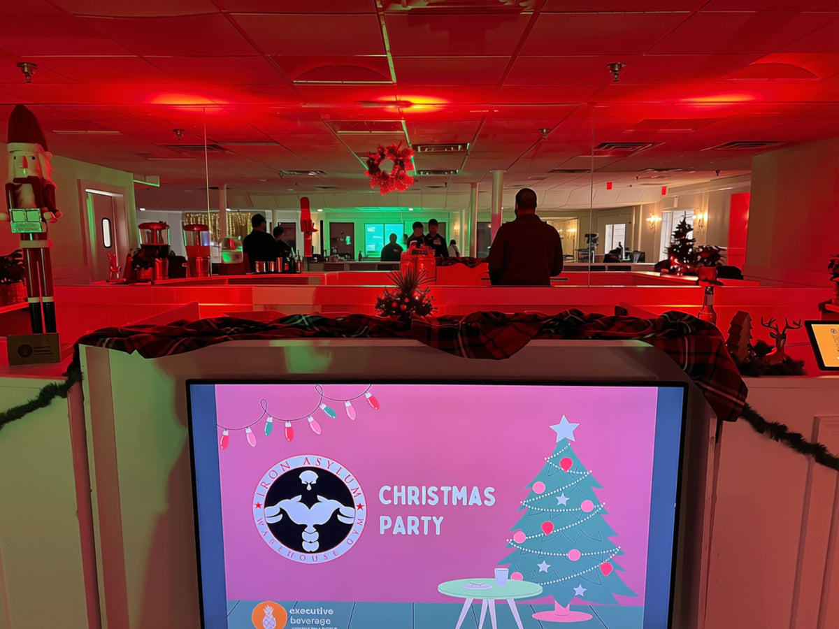 A corporate Christmas party ballroom lit in red with an Executive Beverage bar in service
