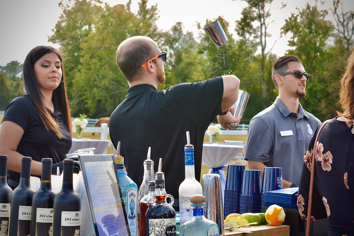 An Executive Beverage bartender shaking a cocktail while guests watch at a private class in Virginia Beach