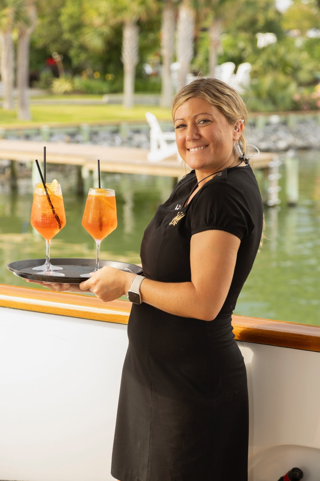 An Executive Beverage server carrying a tray of cocktails at a waterfront event in Virginia Beach