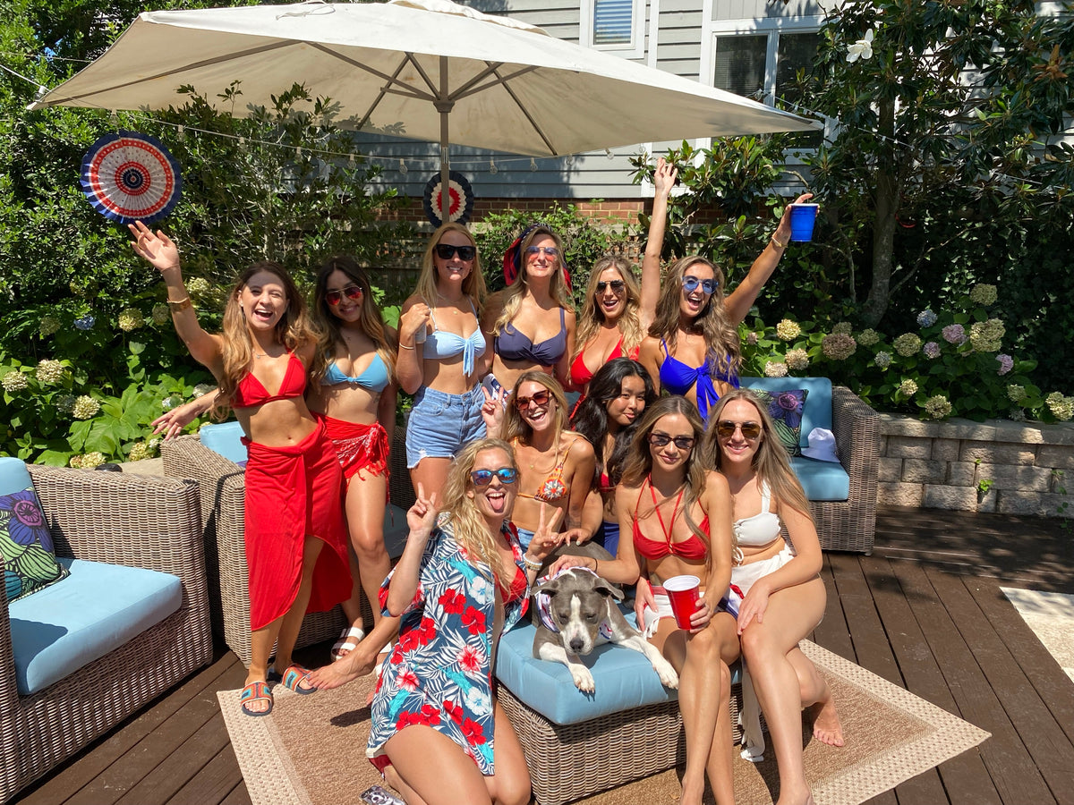 Guests celebrating on the deck of a beach house at a Fourth of July party served by an Executive Beverage mobile bar.