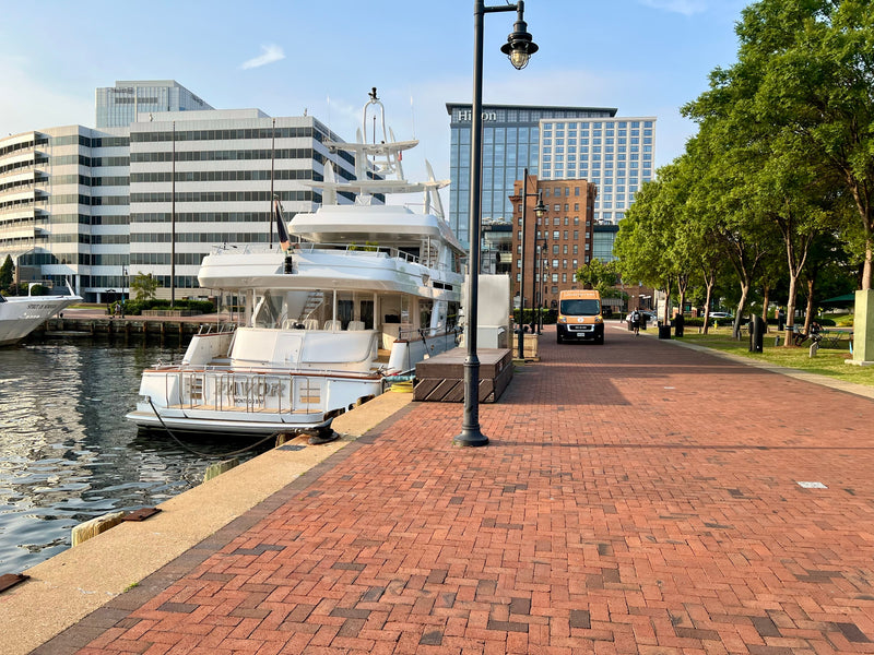 The yacht My Favor alongside a brick waterfront promenade before a private charter bar service.